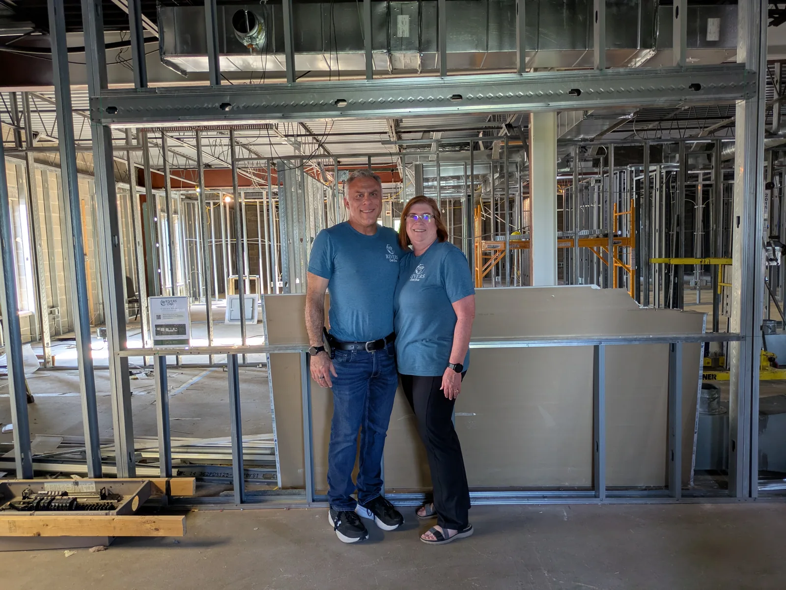 Lynne and James standing inside the framed-out Fifty5 Rivers Cafe space during the Beavercreek Chamber of Commerce hard hat tour
